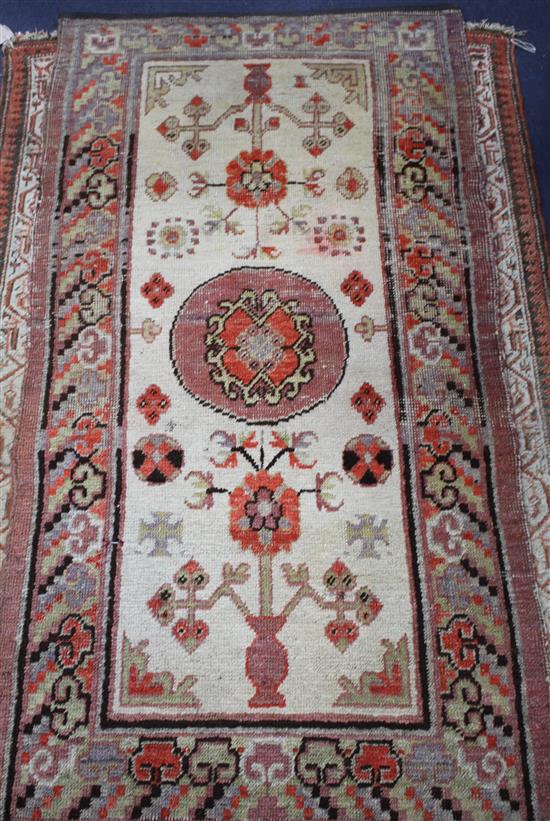 An Antique Khotan rug, with stylised floral motifs on a cream ground, multi-bordered, 145 x 75cm
